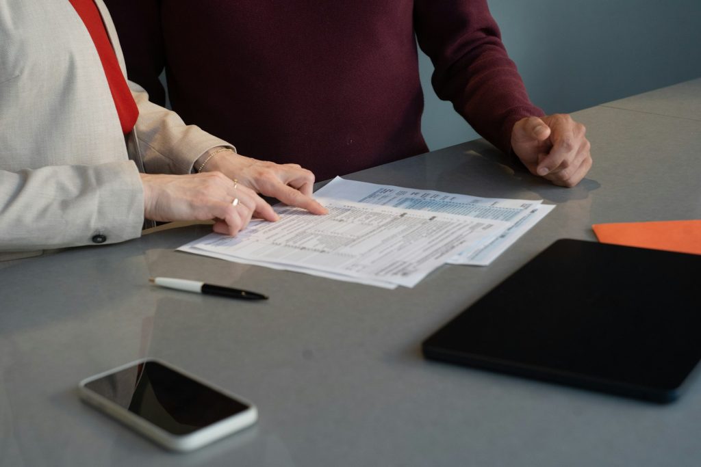Deux personnes examinent des documents posés sur une table